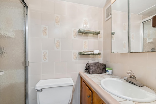 bathroom with a shower stall and tile walls