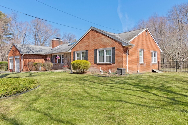 rear view of house with a yard, brick siding, and a chimney