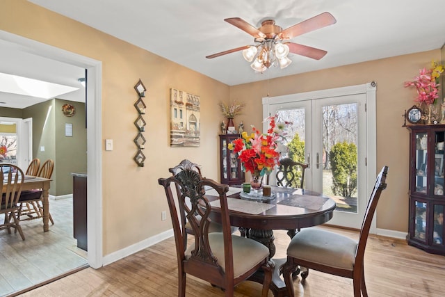 dining space with ceiling fan, french doors, baseboards, and light wood-style floors