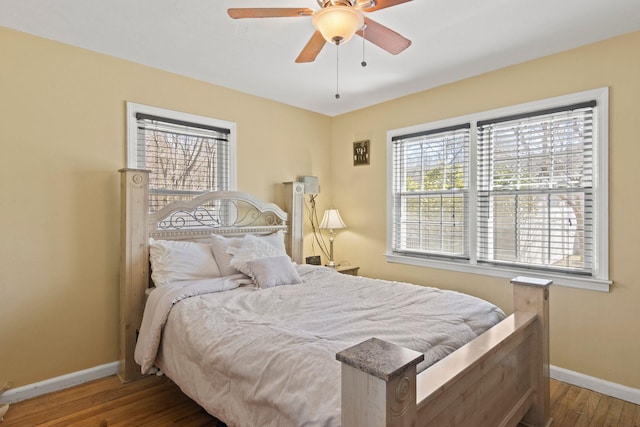 bedroom with ceiling fan, baseboards, and wood finished floors