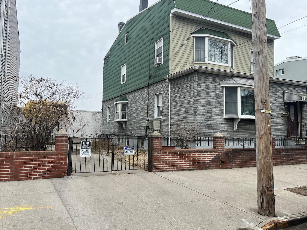 view of property exterior featuring a gate, cooling unit, driveway, a chimney, and a fenced front yard