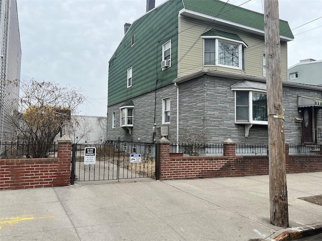 view of property exterior featuring a gate, cooling unit, driveway, a chimney, and a fenced front yard