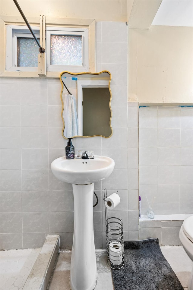 full bathroom featuring toilet, tile walls, and a tile shower