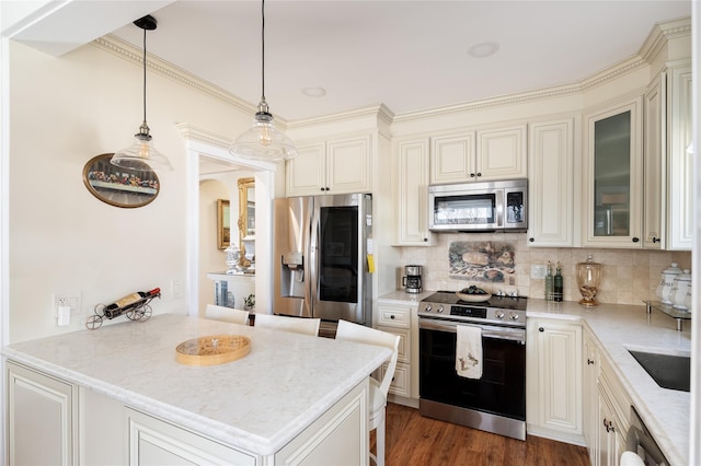 kitchen with stainless steel appliances, tasteful backsplash, a breakfast bar area, light stone counters, and a peninsula