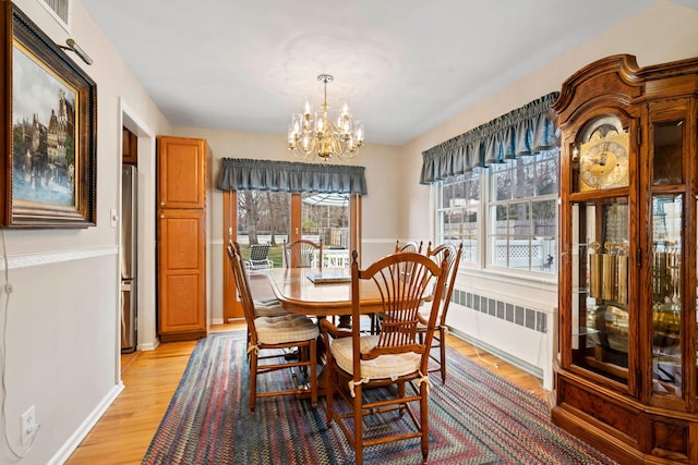 14 Hillside Ave, Saint James, NY 11780 - dining space featuring radiator, light wood finished floors, a chandelier, and baseboards