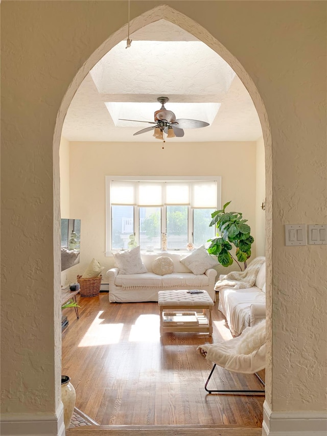 119 Mitchell Ave, Long Beach, NY 11561 - living area with arched walkways, ceiling fan, and a textured wall