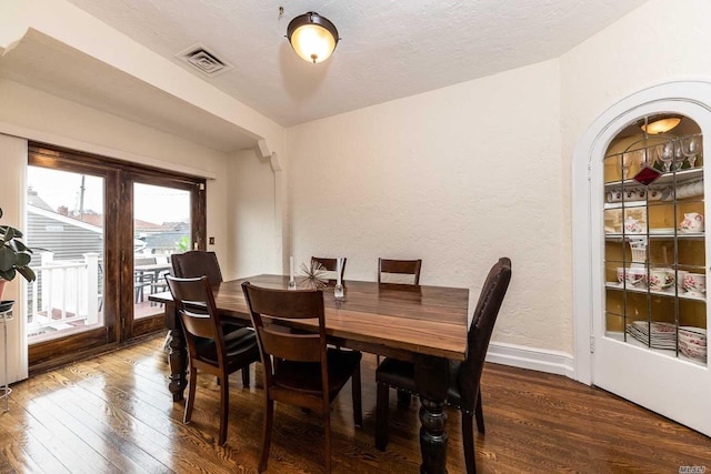 119 Mitchell Ave, Long Beach, NY 11561 - dining space featuring a textured ceiling, baseboards, visible vents, hardwood / wood-style flooring, and a textured wall