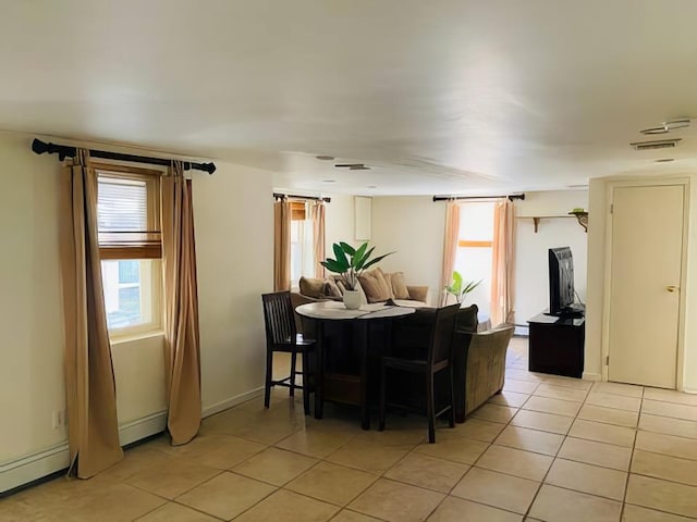 119 Mitchell Ave, Long Beach, NY 11561 - dining area with light tile patterned floors, plenty of natural light, visible vents, and a baseboard heating unit