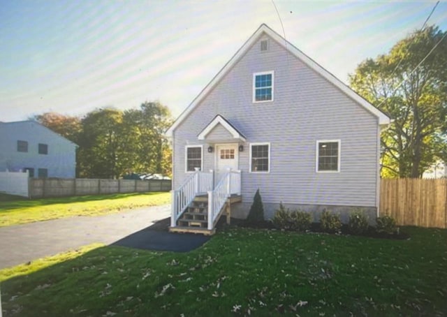 bungalow-style home featuring a front lawn and fence