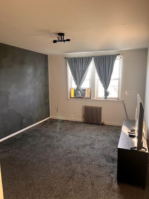 133-25 Blossom Ave, Flushing, NY 11355 - empty room featuring cooling unit, baseboards, and radiator