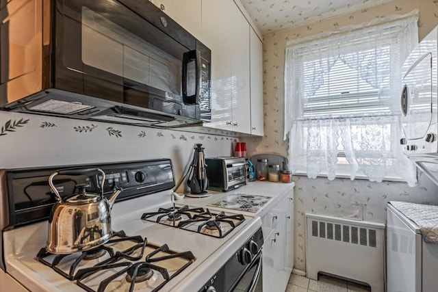 58-30 251st St Unit 2Nd, Little Neck, NY 11362 - kitchen with wallpapered walls, radiator heating unit, light countertops, and white gas range oven