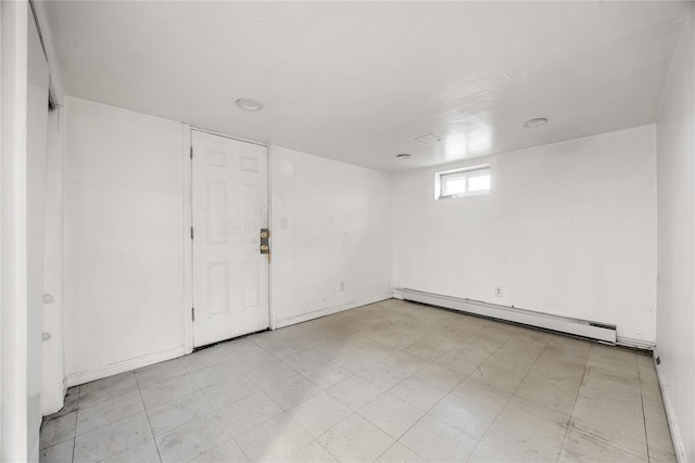 basement with a baseboard heating unit and light floors