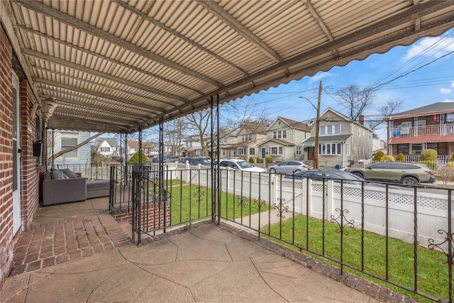 view of patio / terrace with a residential view and fence