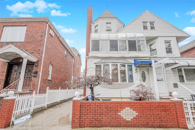 view of front of property with a sunroom and fence