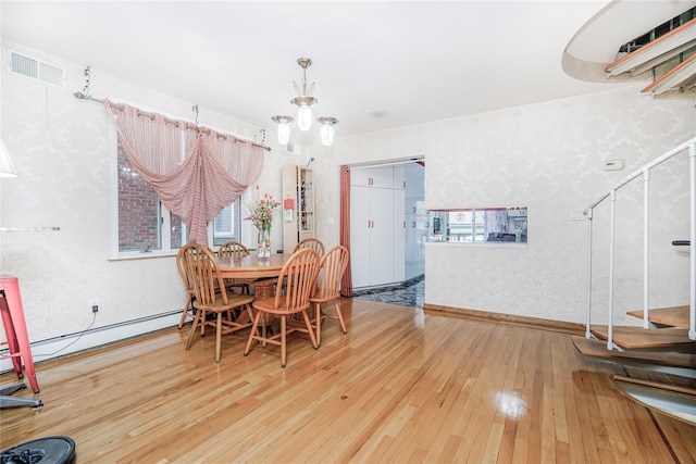 dining space featuring baseboards, a baseboard radiator, visible vents, and hardwood / wood-style flooring