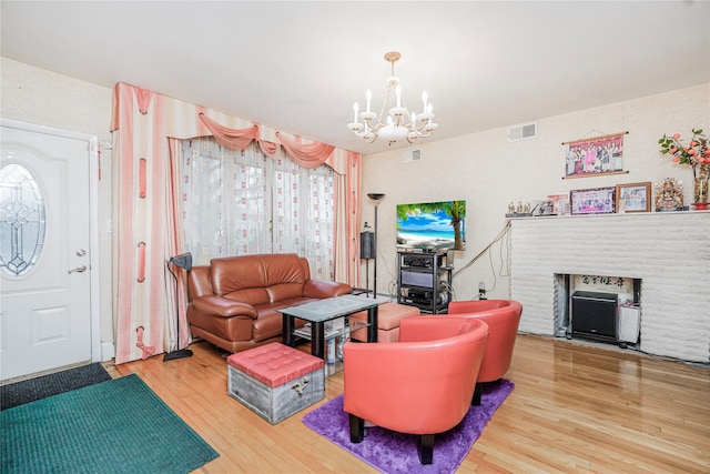 living area with visible vents, a notable chandelier, and wood finished floors