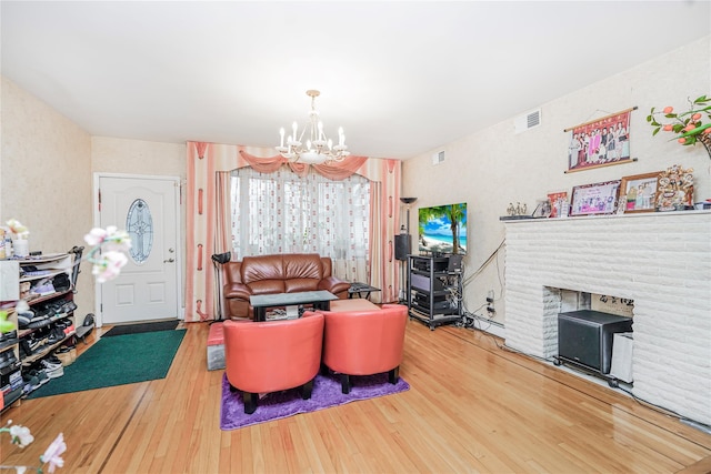 living area featuring visible vents, hardwood / wood-style flooring, and an inviting chandelier