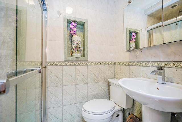bathroom featuring tile walls, toilet, and a sink
