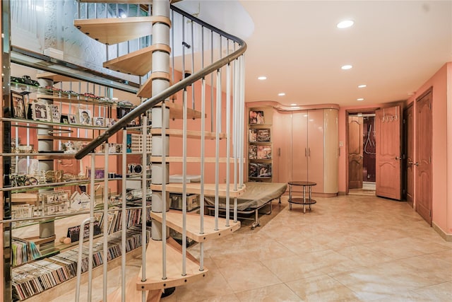 staircase with tile patterned floors and recessed lighting