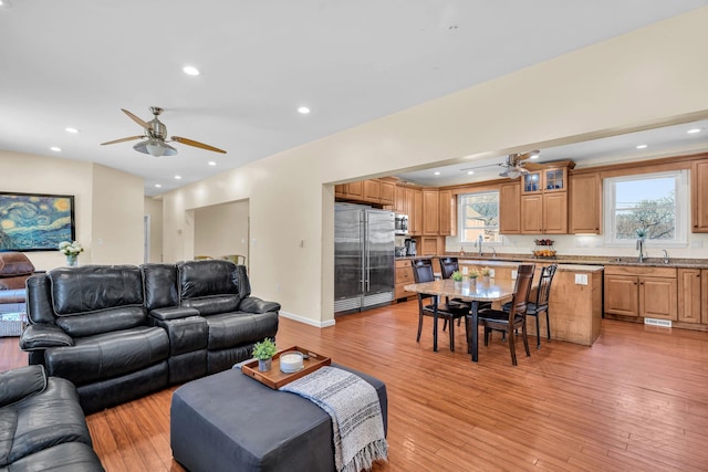 living room with recessed lighting, a ceiling fan, light wood-type flooring, and baseboards