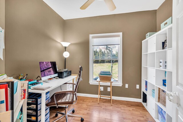 office area featuring a healthy amount of sunlight, a ceiling fan, baseboards, and wood finished floors