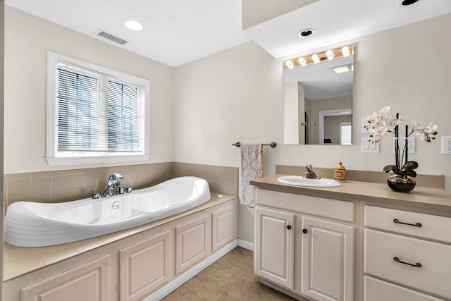 bathroom with tile patterned floors, visible vents, recessed lighting, a bath, and vanity