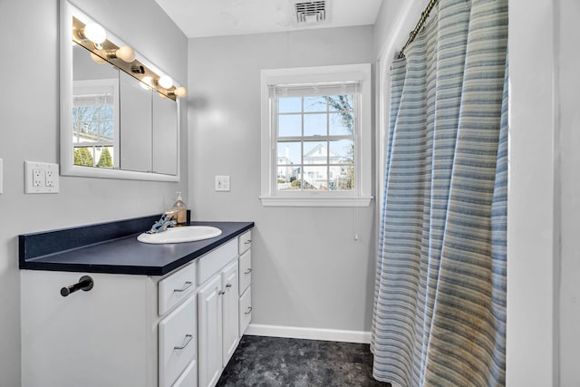 bathroom featuring visible vents, baseboards, and vanity