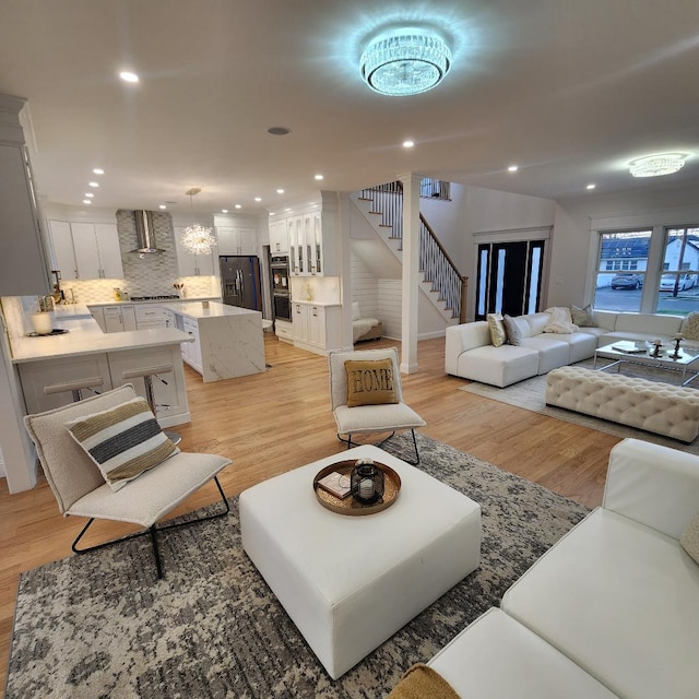 living room with light wood-type flooring, recessed lighting, and stairs