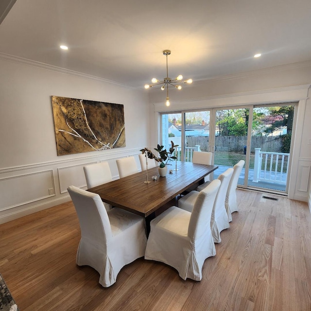 dining area featuring recessed lighting, an inviting chandelier, ornamental molding, and light wood finished floors