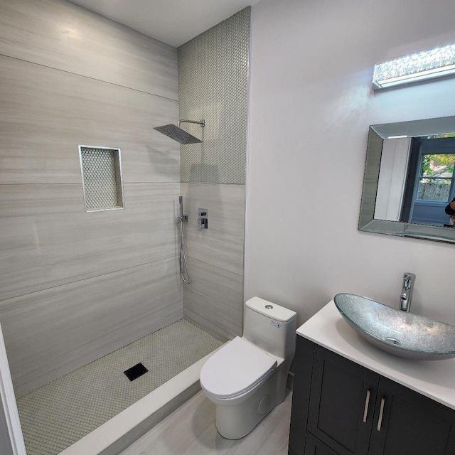 full bath with vanity, toilet, and tiled shower