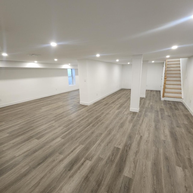 basement with stairs, recessed lighting, baseboards, and wood finished floors