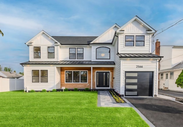 2566 Aster Pl N, Westbury, NY 11590 - view of front of property with a standing seam roof, an attached garage, board and batten siding, driveway, and a metal roof