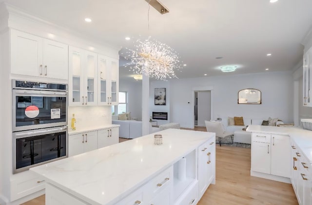2566 Aster Pl N, Westbury, NY 11590 - kitchen featuring double oven, open floor plan, white cabinets, and recessed lighting