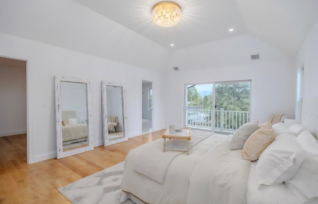 2566 Aster Pl N, Westbury, NY 11590 - bedroom with a chandelier, vaulted ceiling, access to exterior, and light wood-style floors