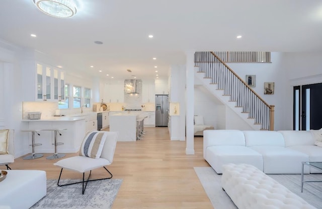 2566 Aster Pl N, Westbury, NY 11590 - living room featuring light wood-style floors, stairs, and recessed lighting