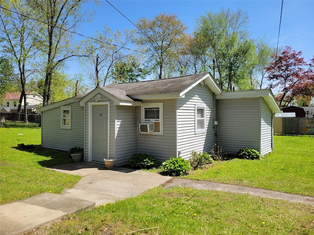view of front facade featuring fence, cooling unit, and a front lawn