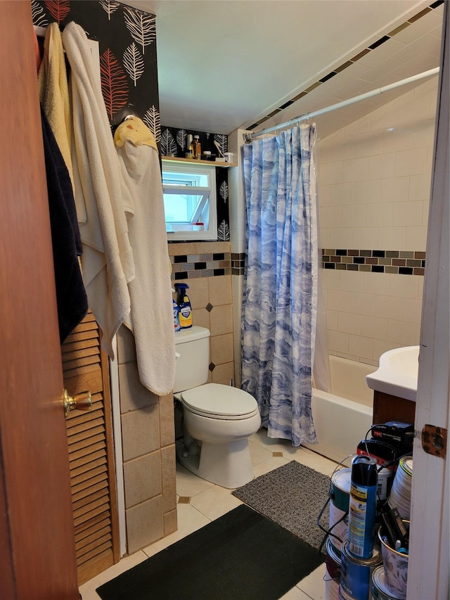 bathroom with toilet, tile patterned floors, tile walls, and shower / bathtub combination with curtain