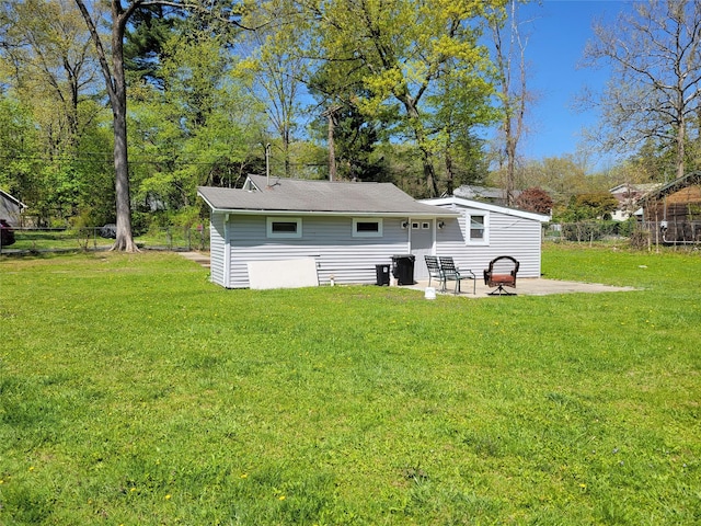 rear view of property with a patio area, fence, and a yard