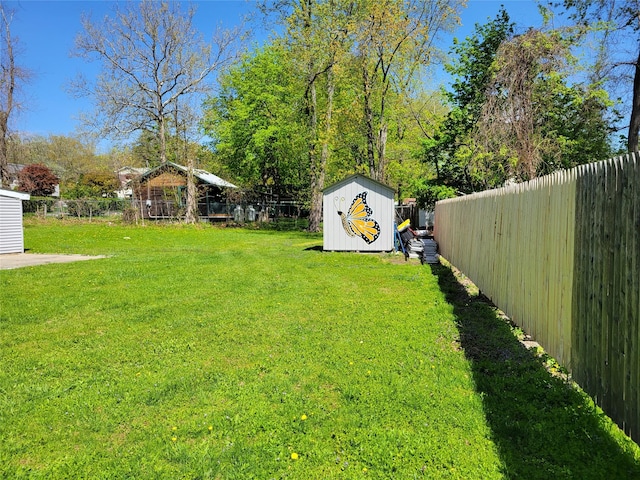 view of yard featuring an outdoor structure, a shed, and a fenced backyard