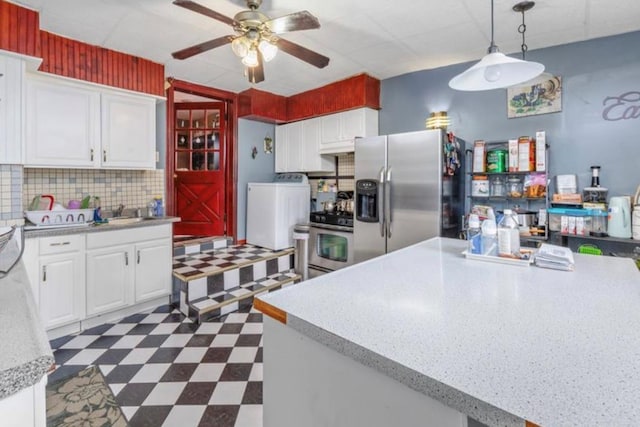 11812 Francis Lewis Blvd, Cambria Heights, NY 11411 - kitchen with a ceiling fan, washer / clothes dryer, stainless steel appliances, dark floors, and light countertops