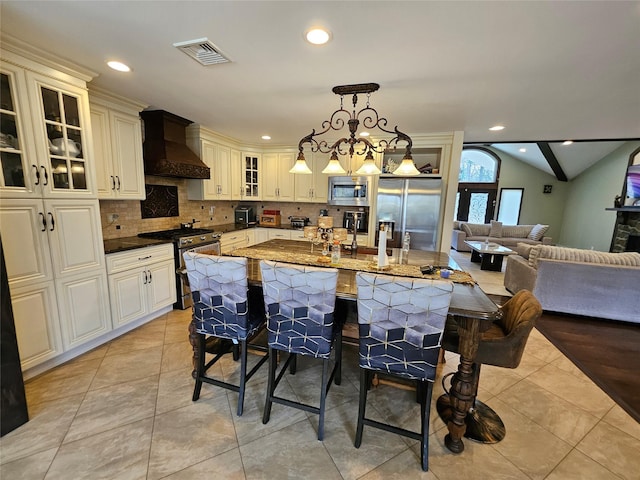7 Raynham Rd, Glen Cove, NY 11542 - kitchen featuring appliances with stainless steel finishes, custom range hood, a breakfast bar, decorative backsplash, and open floor plan