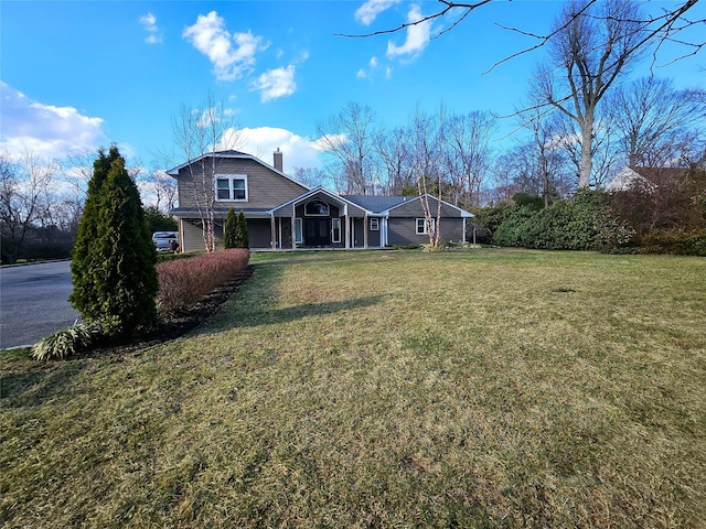 7 Raynham Rd, Glen Cove, NY 11542 - back of property featuring a chimney, a lawn, and a porch
