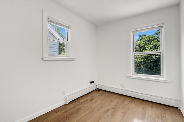 48-35 Clearview Expy, Bayside, NY 11364 - unfurnished room with healthy amount of natural light, wood finished floors, and a baseboard heating unit