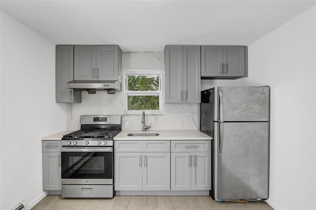 48-35 Clearview Expy, Bayside, NY 11364 - kitchen featuring stainless steel appliances, under cabinet range hood, gray cabinets, light countertops, and light wood-style floors