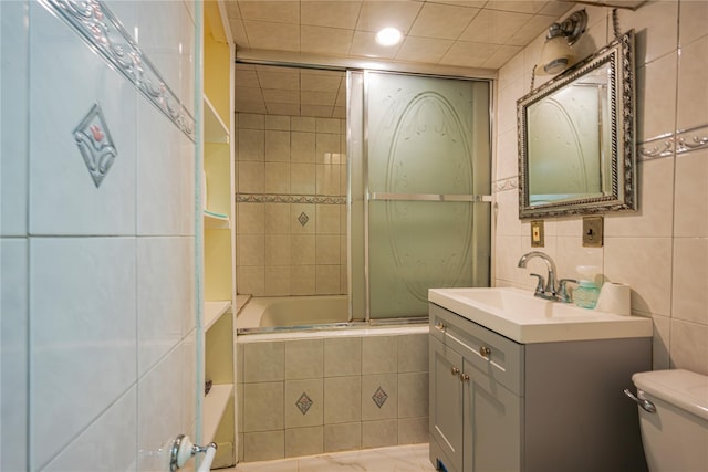 bathroom featuring tiled shower / bath combo, toilet, tile walls, and vanity