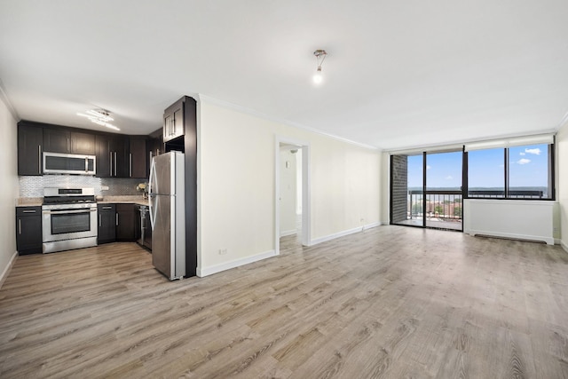 2 Bay Club Dr Unit 17Z2, Bayside, NY 11360 - kitchen with stainless steel appliances, light countertops, open floor plan, light wood-style flooring, and tasteful backsplash