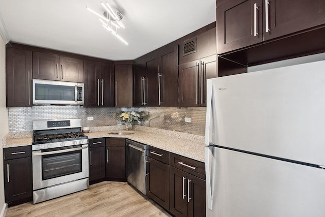 2 Bay Club Dr Unit 17Z2, Bayside, NY 11360 - kitchen featuring stainless steel appliances, dark brown cabinets, backsplash, light wood finished floors, and light stone countertops
