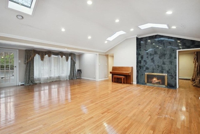 unfurnished living room featuring crown molding, a fireplace, recessed lighting, wood finished floors, and lofted ceiling with skylight