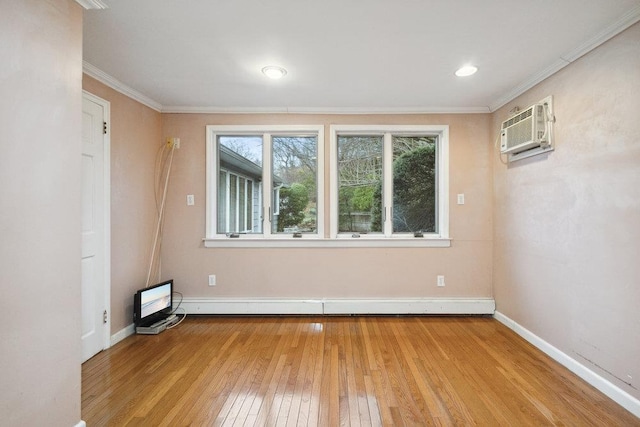 spare room with a baseboard radiator, baseboards, light wood finished floors, and a wall mounted AC