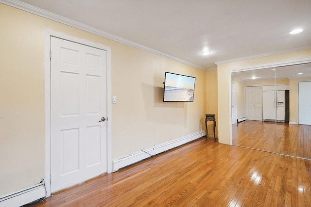 spare room with ornamental molding, a baseboard radiator, light wood finished floors, recessed lighting, and a baseboard heating unit